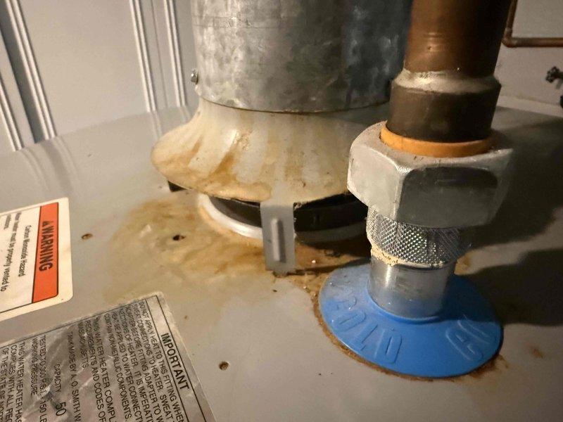 Completed comprehensive HVAC tune-up on 3-year-old system located in basement, including full inspection of furnace, humidifier, thermostat, and hot water tank. Documented water heater condition with visible rust staining around base mounting bracket and drain pan area requiring monitoring for potential leak development. All mechanical systems inspected and operational at time of service.