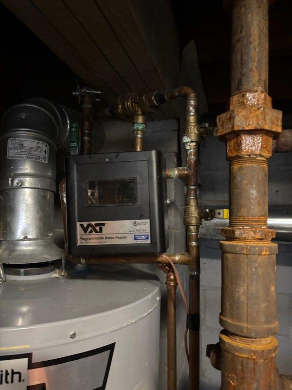Responded to emergency call for Weil-McLain steam boiler actively leaking water in basement. Upon inspection, identified failed water feeder valve (VXT unit) with corroded brass fittings and union connections showing significant oxidation and deterioration. Shut down boiler system and replaced defective water feeder valve assembly, including associated corroded brass fittings and unions. Tested system for proper operation and verified no active leaks present. System restored to normal operation with all components functioning correctly.