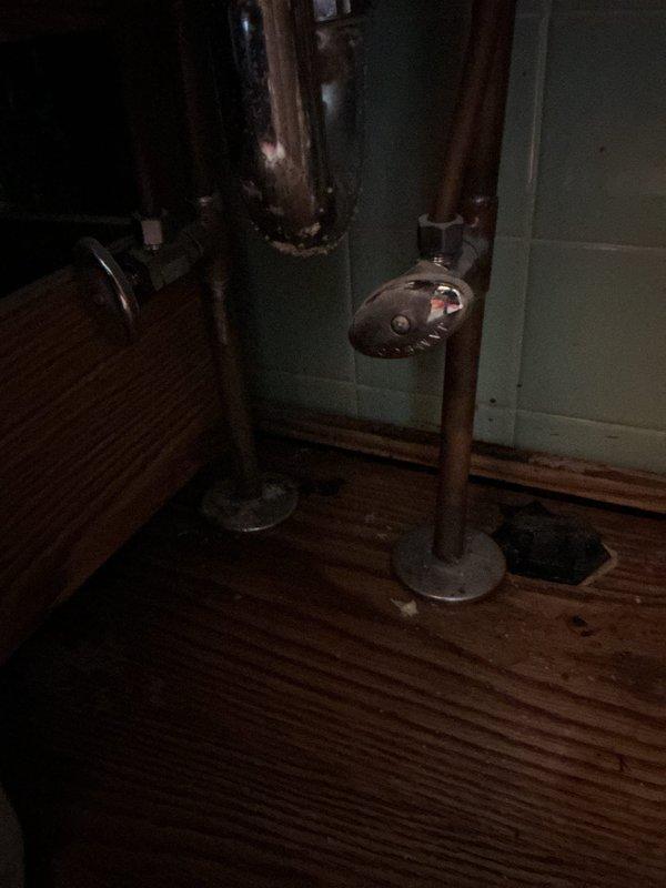 Responded to service call for two water leaks at residential property. Inspected bathroom sink drain trap area where homeowner suspected leak origin and confirmed moisture presence. Assessed basement utility area where copper plumbing line showed active leak at flanged connection point. Evaluated utility sink plumbing system with visible corrosion and mineral buildup on fixtures. Repaired leak sources, tested all connections for proper seal, and verified no additional water discharge from affected areas.