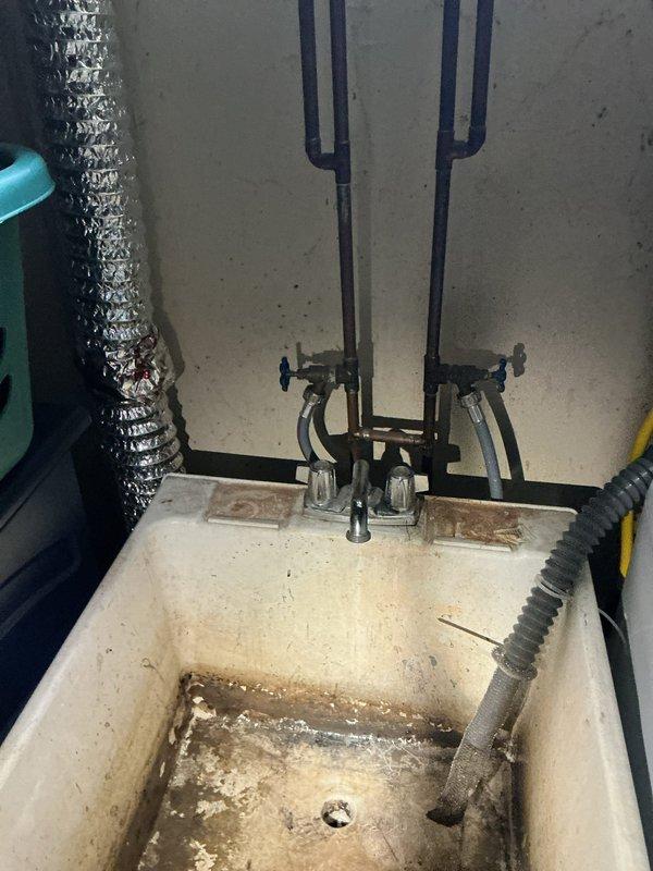 Responded to service call for two water leaks at residential property. Inspected bathroom sink drain trap area where homeowner suspected leak origin and confirmed moisture presence. Assessed basement utility area where copper plumbing line showed active leak at flanged connection point. Evaluated utility sink plumbing system with visible corrosion and mineral buildup on fixtures. Repaired leak sources, tested all connections for proper seal, and verified no additional water discharge from affected areas.