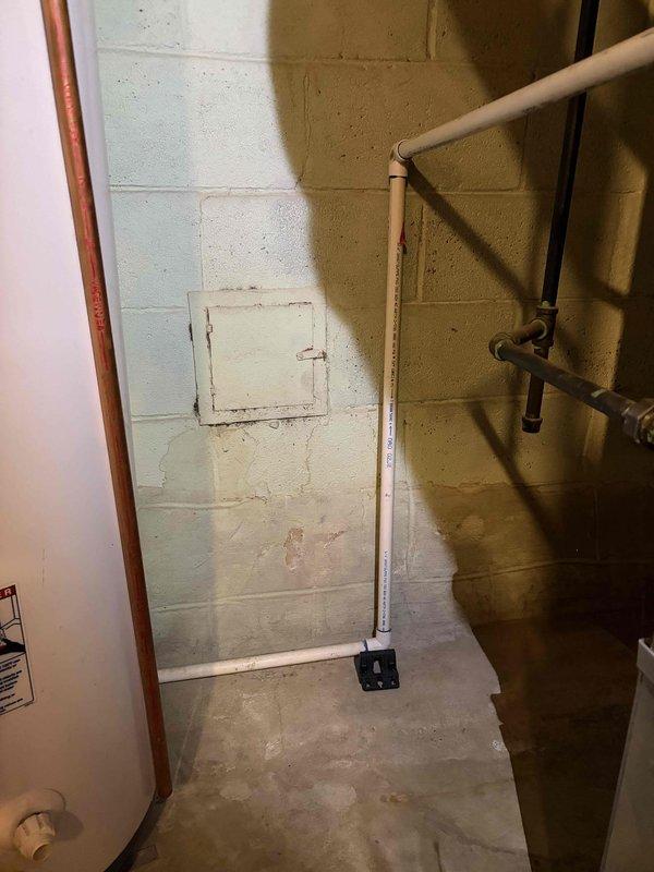 Responded to service call for reported leak originating from furnace system. Upon inspection of the basement-installed Trane forced air furnace (10+ years old), evaluated all visible plumbing connections, condensate drain lines, and PVC discharge piping for signs of active leakage or moisture accumulation. Examined the white PVC condensate drain line extending from the furnace, inspecting all joints, connections, and the floor-mounted base assembly for proper seal integrity. Assessed the condition of all ductwork connections, including the vertical cylindrical supply duct and return air plenum attachments, to rule out secondary moisture sources. Verified proper drainage function and confirmed no obstructions in the condensate removal system. Documented equipment condition and piping configuration with photographic evidence for service records.