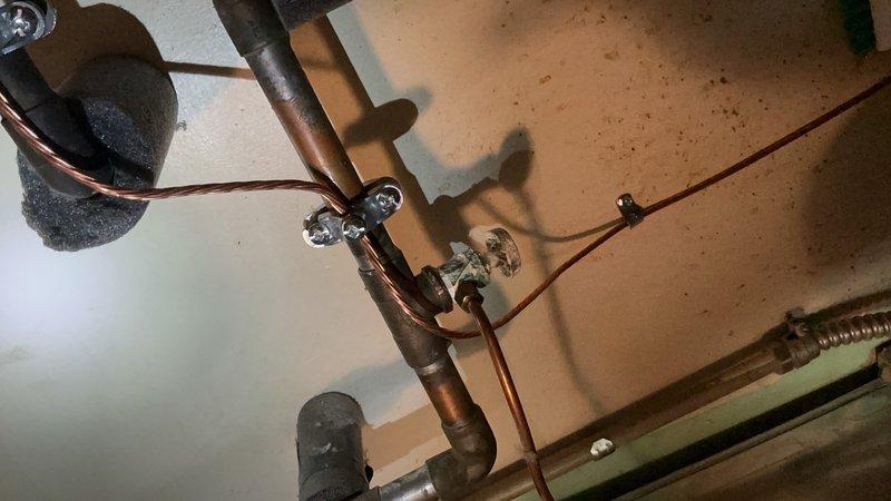 Completed comprehensive Gold-level furnace inspection on 10+ year old forced air heating system located in basement. Unit was operational at time of service. Identified issue with humidifier feed line requiring repair—marked sections of piping for cut-out and replacement with coupling and shark bite humidifier feed valve to restore proper water supply to humidification system. Documented existing plumbing configuration including copper supply lines, shut-off valves, and connection points for future reference and corrective action.