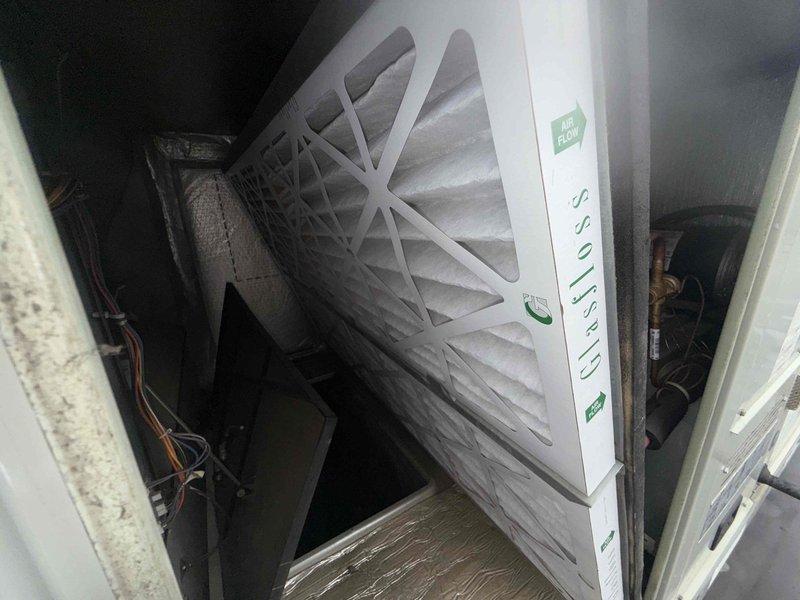 Performed scheduled filter change on commercial rooftop unit. Accessed RTU via roof, removed existing air filter from air handling compartment, and installed new pleated filter with proper orientation within metal housing. Verified filter fit and secure placement within ductwork system, ensured all access panels were properly closed, and confirmed unit operation upon completion.