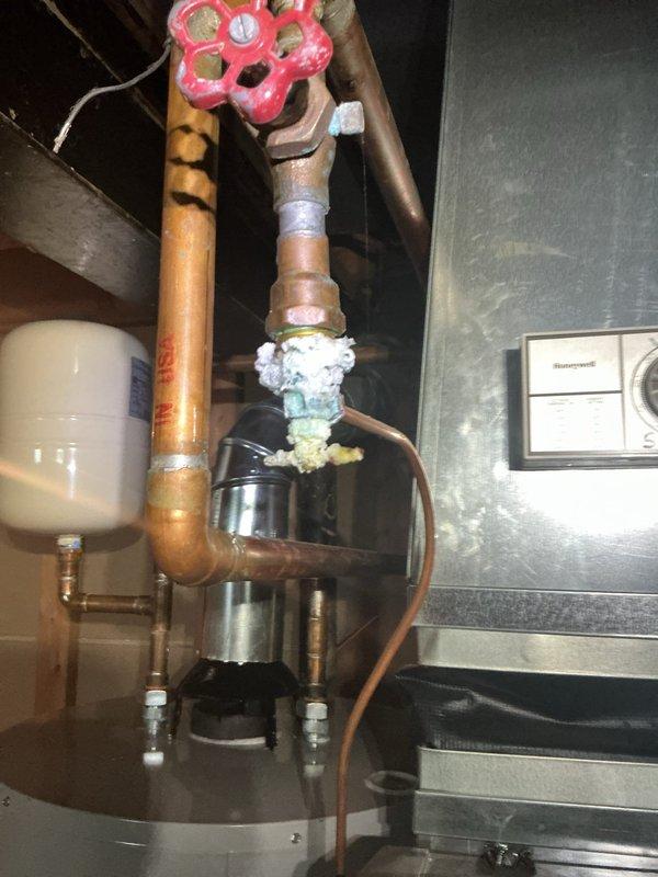 Completed comprehensive tune-up and inspection on 17-year-old Bryant furnace system located in basement as part of complimentary Gold maintenance plan visit. Performed thorough cleaning of burner assembly, heat exchanger inspection, blower motor lubrication, and combustion analysis to ensure optimal efficiency and safe operation. Inspected Honeywell humidifier unit mounted to supply ductwork and verified proper operation and water supply connections. Observed corrosion and mineral deposits on copper plumbing connections near expansion tank, documented condition with photos for customer awareness. Checked all electrical connections, tested ignition sequence, verified proper flame sensor operation, and confirmed adequate airflow throughout system. Filter replaced, thermostat operation verified, and all safety controls tested within manufacturer specifications. System operating safely with no immediate concerns; recommend monitoring copper piping corrosion for potential future service nee