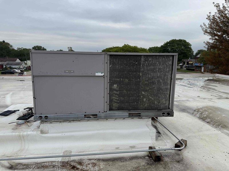 Responded to service call for rooftop unit not operating properly at commercial facility. Accessed RTU via ladder on flat membrane roof. Upon inspection, found unit's filter/coil section heavily contaminated with dirt and debris accumulation, restricting airflow and reducing system efficiency. Documented existing conditions showing significant soiling on coil guard and general unit maintenance needs. Unit requires thorough coil cleaning and filter replacement to restore proper operation and cooling capacity.
