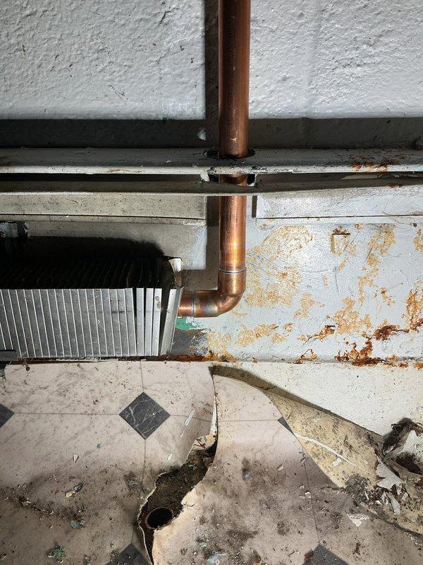 Completed comprehensive boiler repair work in basement utility area per approved estimate. Addressed copper piping connections, including vertical supply lines and horizontal elbow joints, with replacement of corroded sections showing significant rust staining on walls and floor. Repaired radiator heat exchanger system and associated mounting hardware, ensuring proper functionality of heating distribution components. All work completed with financing documentation processed and signed by loan holder, with identification verified and retained on file.