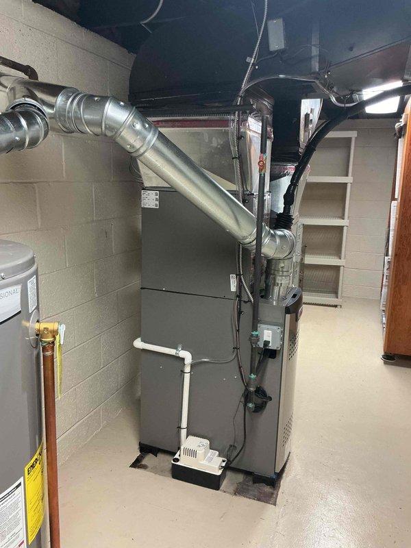 Completed full HVAC system installation in basement mechanical room, including 70,000 BTU furnace, 2-ton air conditioning unit, programmable thermostat, humidifier, and condensate pump. Installed new ductwork with metallic flexible and rigid connections from air handler to ceiling distribution points. Ran electrical wiring and mounted control components on furnace unit. Connected condensate pump with drainage lines and performed system flush. Secured mechanical and electrical permits prior to installation. Reconnected all utility connections and tested system operation to verify proper heating and cooling functionality.