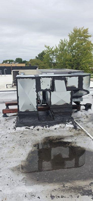 Conducted comprehensive site assessment of fire-damaged commercial rooftop HVAC unit to provide detailed ductwork and equipment replacement estimate. Unit sustained catastrophic fire damage with extensive charring, soot accumulation, warped panels, and compromised internal components rendering equipment completely non-functional. Documented extensive damage to metal casing, structural framework, and all mechanical systems through photographic evidence for insurance and replacement specifications.