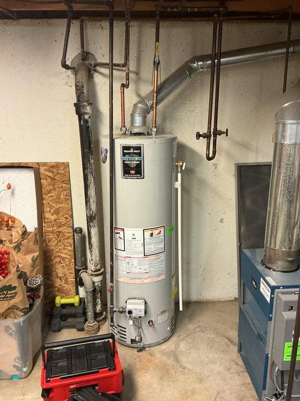 Completed comprehensive Gold furnace inspection on an 8-year-old boiler system located in basement. Performed thorough visual examination of blue metal boiler unit, expansion tank, and associated heating components. Inspected all copper piping connections, shut-off valves, and pressure gauges throughout the system for proper operation and potential leaks. Evaluated water heater connections and temperature/pressure relief valve configuration. Checked galvanized ductwork connections and mounting integrity of expansion tank. Assessed condition of black vertical pipes, noting visible corrosion and mineral buildup on one section that will require monitoring. Verified proper installation of pipe hangers and support systems throughout mechanical room. Examined HVAC air filter condition and accessibility. All equipment currently operational with no immediate service requirements identified. System functioning within normal parameters at time of inspection.