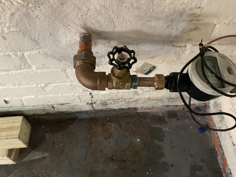 Completed steam boiler line repairs including replacement of corroded brass fittings and compression connections on the horizontal supply piping. Installed new shut-off valve with wheel handle and re-piped sections of copper line running through floor joists to ensure proper flow and eliminate leaks. Insulated vertical pipe penetration through ceiling to prevent heat loss and secured with appropriate banding.