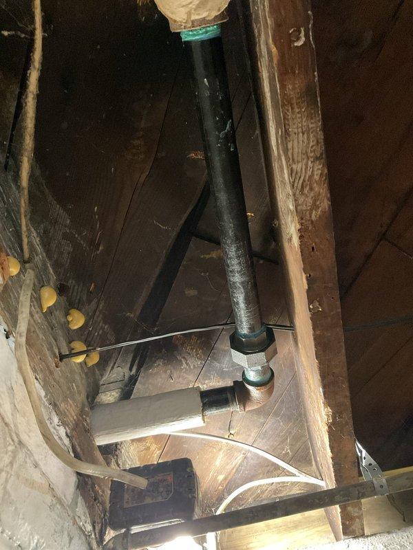 Completed steam boiler line repairs including replacement of corroded brass fittings and compression connections on the horizontal supply piping. Installed new shut-off valve with wheel handle and re-piped sections of copper line running through floor joists to ensure proper flow and eliminate leaks. Insulated vertical pipe penetration through ceiling to prevent heat loss and secured with appropriate banding.