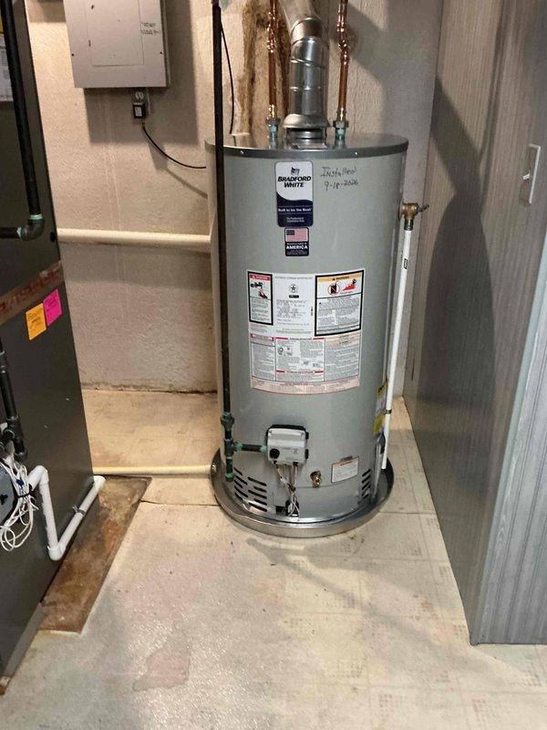 Completed installation of a 50-gallon standard residential water heater in basement utility room. Installed new unit with proper drip pan and drain line per specifications. Connected all copper supply piping with appropriate shut-off valves and brass fittings at top of unit. Verified all plumbing connections for leaks and proper operation. Reconnected electrical supply from existing panel to water heater. Ensured unit was properly positioned on concrete floor with adequate clearance for maintenance and code compliance. All manufacturer labels and safety information remain visible and intact. System tested and confirmed operational upon completion.