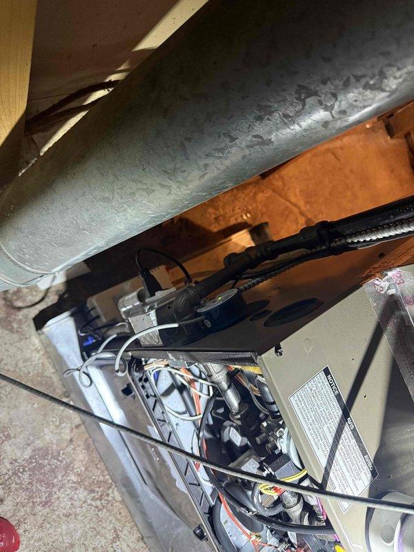 Responded to service call for 2-year-old furnace system not producing adequate heat in basement installation. Upon arrival, performed comprehensive system inspection revealing significant condensation accumulation on supply ductwork and air handler components. Removed access panel to examine internal components including blower assembly, heat exchanger, and control wiring. Inspected evaporator coil condition and verified refrigerant line connections for proper operation. Evaluated air handler electrical connections, safety controls, and thermostat communication circuits. Documented excessive moisture presence on ductwork exterior, indicating potential airflow restriction or humidity imbalance affecting system performance. Checked condensate drainage system and verified proper operation of drain lines and pan. Assessed insulation integrity around installation area and identified areas of concern related to moisture infiltration. Verified all safety switches, limit controls, and flame se