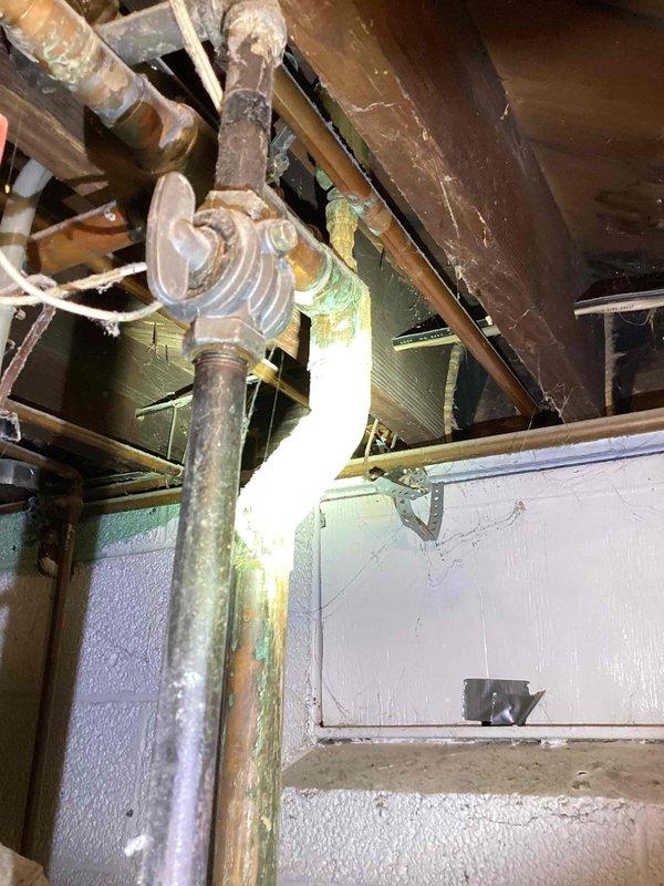 Conducted on-site assessment for boiler replacement in basement location. Evaluated existing 50-year-old boiler system, documenting current installation configuration including vertical piping, expansion tank, and associated mechanical components. Photographed existing equipment showing significant age-related deterioration, oxidized piping, and outdated control systems. Provided comprehensive replacement estimate for new boiler installation to address equipment at end of serviceable life.