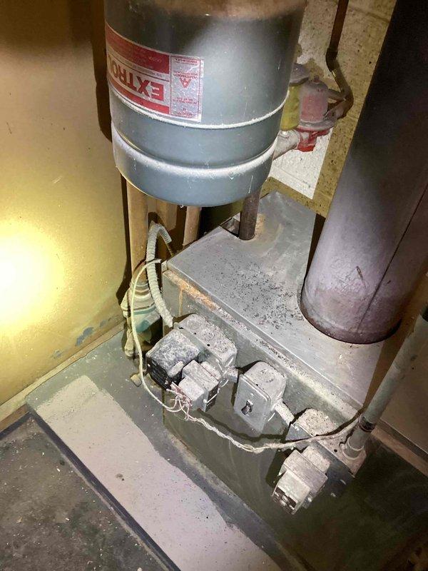 Conducted on-site assessment for boiler replacement in basement location. Evaluated existing 50-year-old boiler system, documenting current installation configuration including vertical piping, expansion tank, and associated mechanical components. Photographed existing equipment showing significant age-related deterioration, oxidized piping, and outdated control systems. Provided comprehensive replacement estimate for new boiler installation to address equipment at end of serviceable life.
