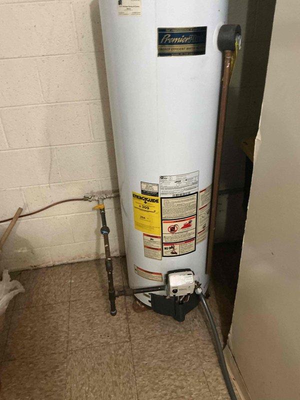 Responded to service call for leaking tanked water heater originally installed in 2007. Performed on-site assessment of Premier brand water heater unit showing signs of age-related deterioration and active leak condition. Documented existing installation including copper supply lines, pressure relief valve, venting configuration, and drain pan placement. Evaluated chimney liner requirements for proper venting of replacement unit and confirmed specifications with homeowner. Provided comprehensive replacement estimate covering removal of failed unit and installation of new tanked water heater system with all necessary connections and code-compliant venting. Estimate was accepted for full water heater replacement to resolve leak issue and restore domestic hot water service.