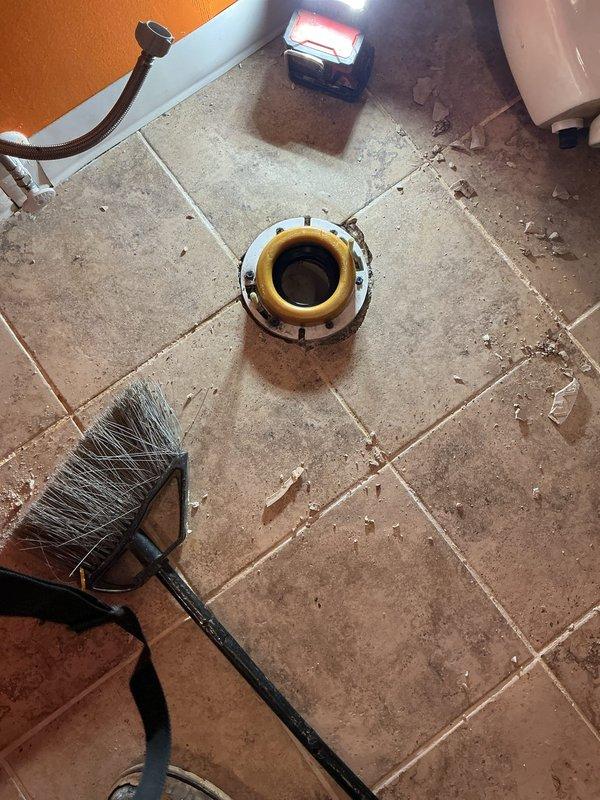Responded to service call for basement plumbing issues involving rusty water from washtub pipes and toilet requiring resealing. Upon inspection, removed and replaced toilet wax ring seal at floor flange to eliminate leak and ensure proper seal between fixture and drain line. Cleaned flange area and surrounding tile, removing debris and preparing surface for reinstallation. Successfully reset toilet to flange with new wax ring, securing unit with bolts and testing for proper seal and function.