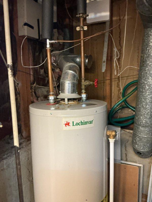 Responded to service call for water leak from 20-year-old Lochinvar hot water heater located in basement with no hot water available. Upon inspection, identified active leak and loss of gas supply to unit. Assessed condition of aging water heater including all plumbing connections, gas line, temperature/pressure relief valve, and control components to determine source of leak and gas interruption.