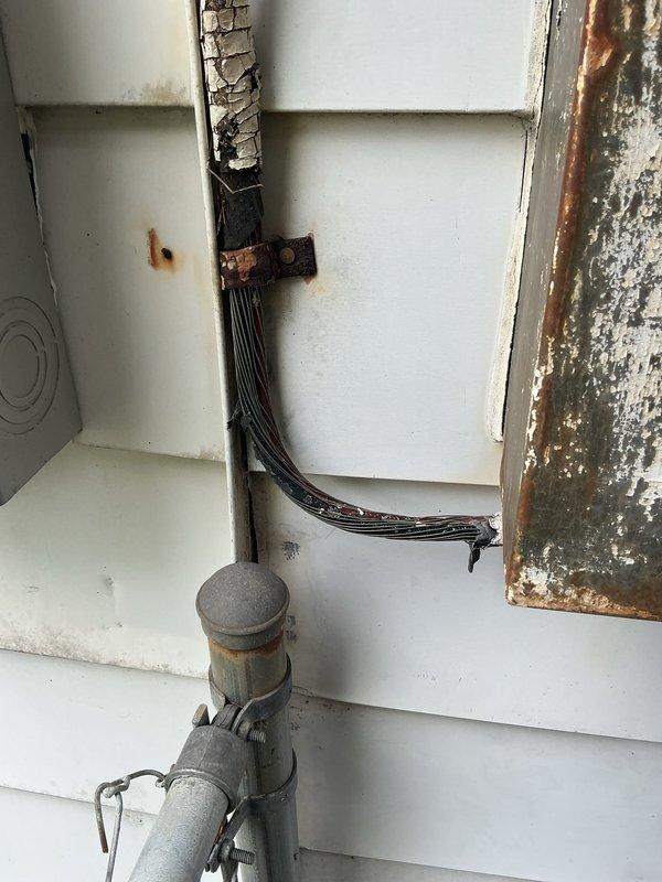 Responded to service call for flickering lights and aging electrical panel. Upon inspection, discovered severely corroded exterior service entrance with deteriorated weatherhead and compromised conduit connections showing extensive rust damage. Interior panels revealed animal nesting material contamination in upper breaker box, creating potential fire hazard and contributing to intermittent electrical issues. Cleaned debris from panel enclosure, inspected all breaker connections and bus bars for signs of overheating or loose connections. Documented multiple code violations including improper wire management and inadequate weather protection at service entrance. Recommended immediate replacement of exterior weatherhead assembly and service entrance components due to safety concerns. Advised scheduling complete panel upgrade to address aging infrastructure, eliminate flickering issues, and bring installation up to current electrical code standards.