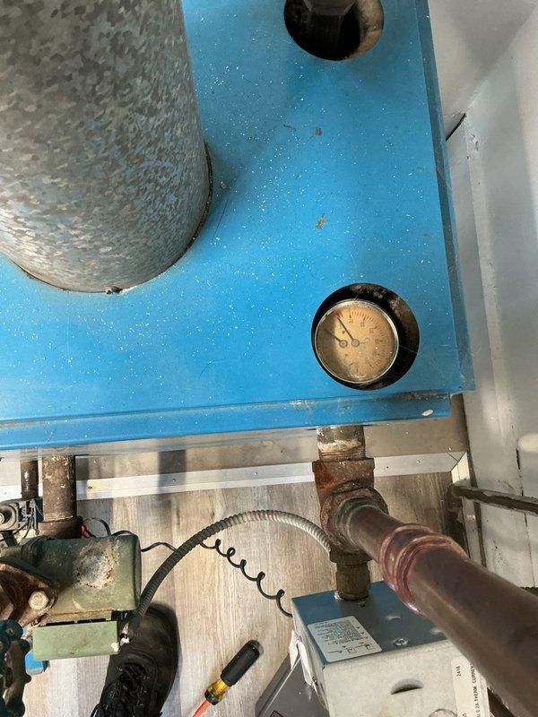 Completed comprehensive inspection and tune-up of residential hot water boiler system located in basement. Performed visual assessment of boiler cabinet, internal components, and insulation integrity. Inspected all visible piping connections, pressure gauge operation, and brass fittings for signs of corrosion or leaks. Evaluated copper piping showing surface oxidation and verified system pressure readings within acceptable parameters. Examined access panel insulation and internal mounting components for proper positioning and condition. System operational at time of inspection with no immediate safety concerns identified.
