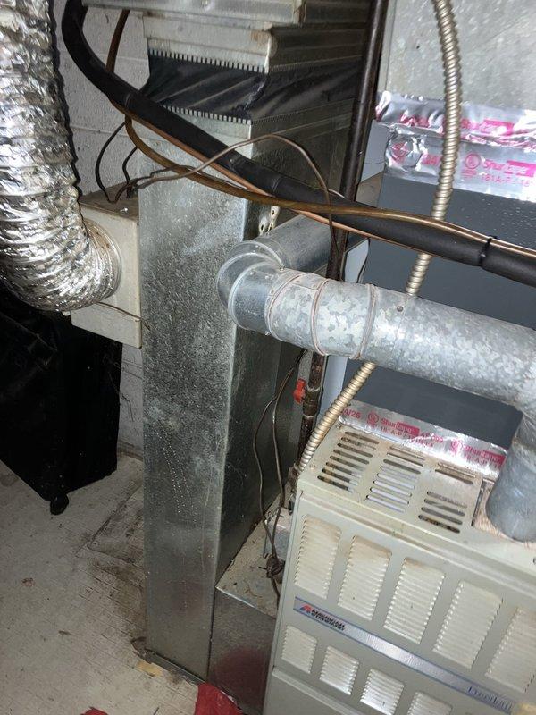 Conducted complimentary estimate for replacement of 30-year-old natural gas furnace located in basement. Evaluated existing HVAC system including ductwork, electrical connections, refrigerant lines, and air handler configuration. Documented current equipment condition through photographs showing aged galvanized ductwork, metallic flex conduit, copper tubing, and existing furnace unit with associated mechanical connections. Provided replacement recommendations based on system assessment.