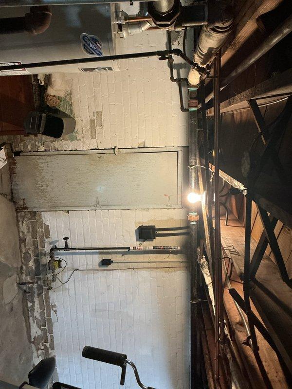 Completed waterline repairs in basement utility area as specified in estimate. Worked with existing copper plumbing system and galvanized ductwork in mechanical room with white painted brick walls. Repairs addressed compromised waterline components, ensuring proper function and integrity of the residential plumbing infrastructure.