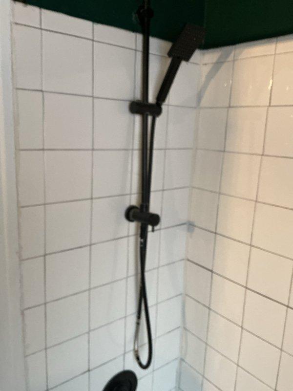 Completed installation of new handheld shower assembly with slide bar and flexible hose in bathtub/shower enclosure. Replaced bathroom sink fixture as requested by homeowner. All fixtures tested for proper water flow and verified leak-free operation upon completion.