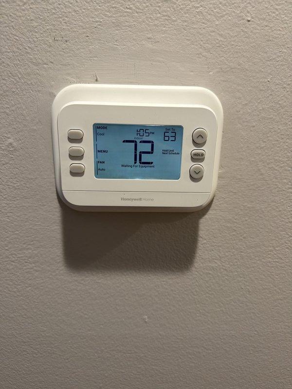 Completed full HVAC system installation including 45,000 BTU furnace, 2-ton air conditioning unit with rear discharge configuration, Honeywell Home programmable thermostat, and humidifier. Requested mechanical and electrical permits prior to installation. Reconnected existing electrical circuits and performed system remeasure for utility rebate qualification. Installed condensate pump and exterior condensate drainage line with PVC piping secured to building exterior. Mounted outdoor condenser unit on exterior wall with proper clearances. Programmed new digital thermostat and verified proper communication with equipment. All systems tested and operational upon completion.