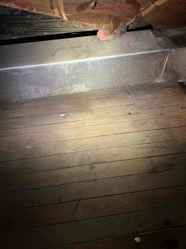 Responded to service call for water leakage from air handler unit installed in 2021 and located in attic. Upon inspection, discovered significant condensation accumulation on supply ductwork due to inadequate insulation. Identified moisture droplets forming on metal duct surfaces, which was causing water to drip onto attic floor. Inspected air handler unit for proper drain line function and confirmed primary and secondary drain lines were clear and operating correctly. Determined the water leakage issue was solely related to duct condensation rather than equipment malfunction. Recommended adding or upgrading duct insulation to prevent future condensation and moisture problems in the unconditioned attic space.