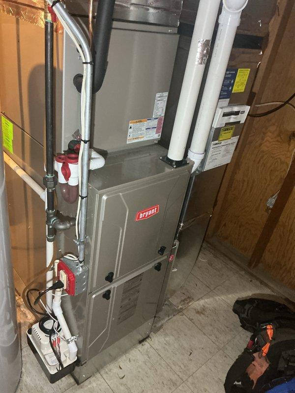 Completed NSP furnace inspection on Bryant unit located in basement mechanical room. Performed comprehensive visual assessment of furnace system, including examination of gas line connections with shutoff valves, PVC venting configuration, and ductwork connections. Verified proper clearances around equipment, inspected manufacturer labels and specifications, and documented system condition through photographic records. Unit appeared to be in good operating condition with organized piping and proper installation standards maintained.