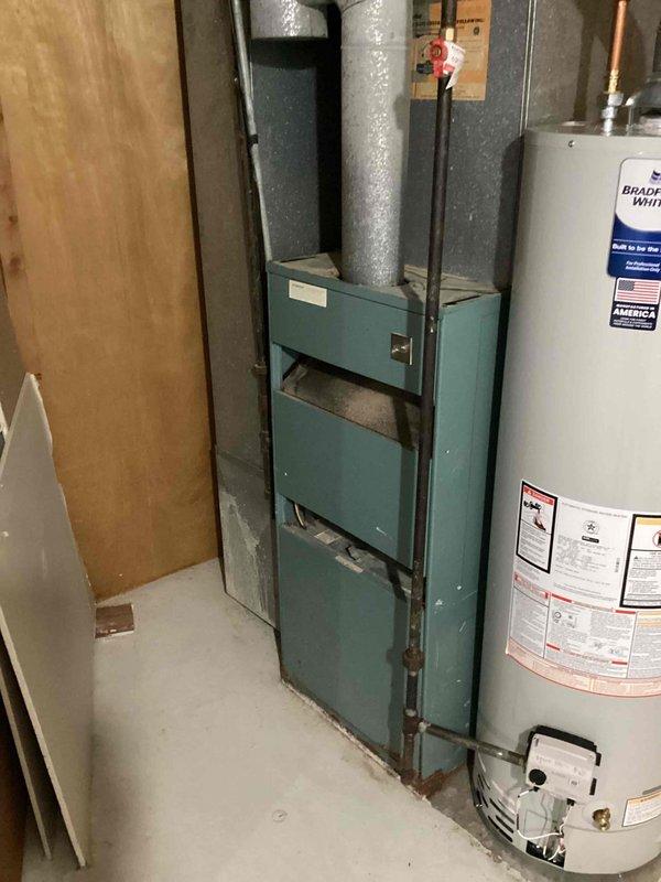 Conducted comprehensive assessment of existing natural gas furnace located in basement utility area for replacement estimate. Current unit is operational but requires evaluation for replacement options. Documented existing HVAC infrastructure including ductwork configuration, venting system, and mechanical room layout to determine appropriate equipment specifications and installation requirements for furnace replacement.