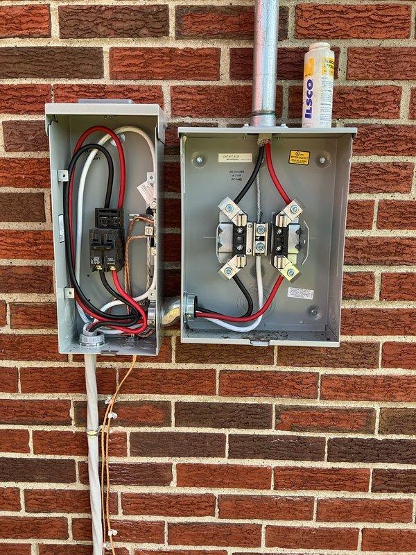 Installed new 100-amp electrical circuit with exterior disconnect boxes mounted on brick wall, including fused disconnect switches and circuit breaker protection. Ran white PVC conduit from roofline through meter box to ground level, completing all necessary wiring connections with appropriate gauge conductors and ensuring proper overcurrent protection for the new circuit installation.