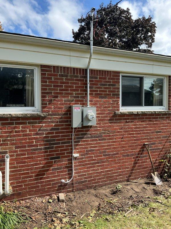Installed new 100-amp electrical circuit with exterior disconnect boxes mounted on brick wall, including fused disconnect switches and circuit breaker protection. Ran white PVC conduit from roofline through meter box to ground level, completing all necessary wiring connections with appropriate gauge conductors and ensuring proper overcurrent protection for the new circuit installation.