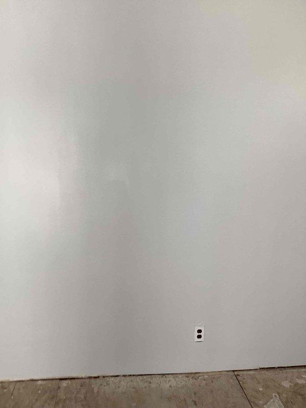 Conducted furnace replacement estimate for residential property where existing heating system had been stolen. Assessed living room area with visible wall markings indicating previous gas furnace installation location, documented existing electrical outlet and concrete floor conditions, and provided recommendations for new gas heating system installation to restore climate control to the unheated dwelling.
