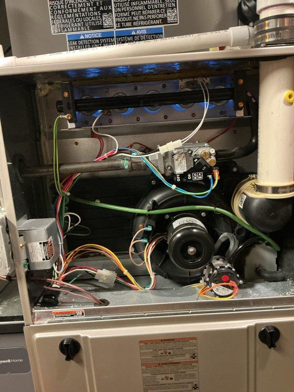 Completed comprehensive tune-up inspection on a 2-year-old residential furnace located in basement. Performed thorough examination of all major components including blower motor assembly, burner assembly with flame sensors, heat exchanger, electrical connections, and control board wiring. Inspected evaporative cooler pad within the system, noting mineral deposits and dust accumulation on the honeycomb cellulose media, which is typical for units in service. Verified proper operation of gas valve controls, checked all wire connections for secure placement, and examined PVC venting system for proper installation. All safety controls, limit switches, and flame sensors tested and functioning within manufacturer specifications. System operational and ready for heating season.