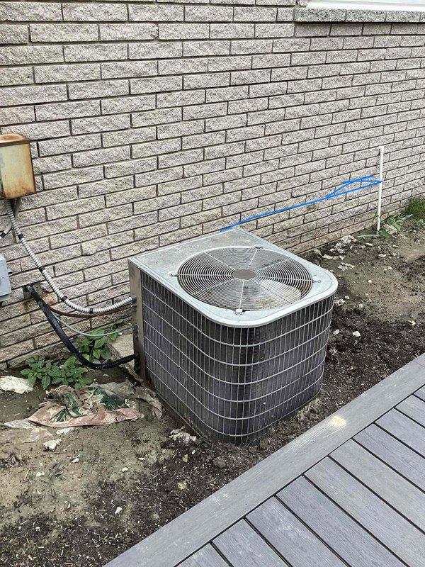 Conducted comprehensive site assessment for complete HVAC system replacement, including furnace and air conditioning unit. Evaluated existing outdoor condensing unit location against brick exterior wall, documented current equipment condition and installation area, and photographed proposed equipment placement zones marked on exterior wall. Assessed refrigerant line routing, electrical conduit pathways, and ground-level installation conditions to provide accurate full system replacement estimate.