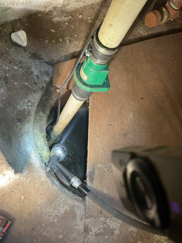 Responded to service call for sump pump replacement initially identified by HVAC technician. Removed existing failed sump pump unit and installed new replacement pump in basement sump pit. Connected discharge piping using PVC and flexible connections with stainless steel hose clamps and green coupling adapter to ensure proper water evacuation from pit. Verified pump operation, tested float switch functionality, and confirmed proper drainage through existing discharge line. System operational upon completion.