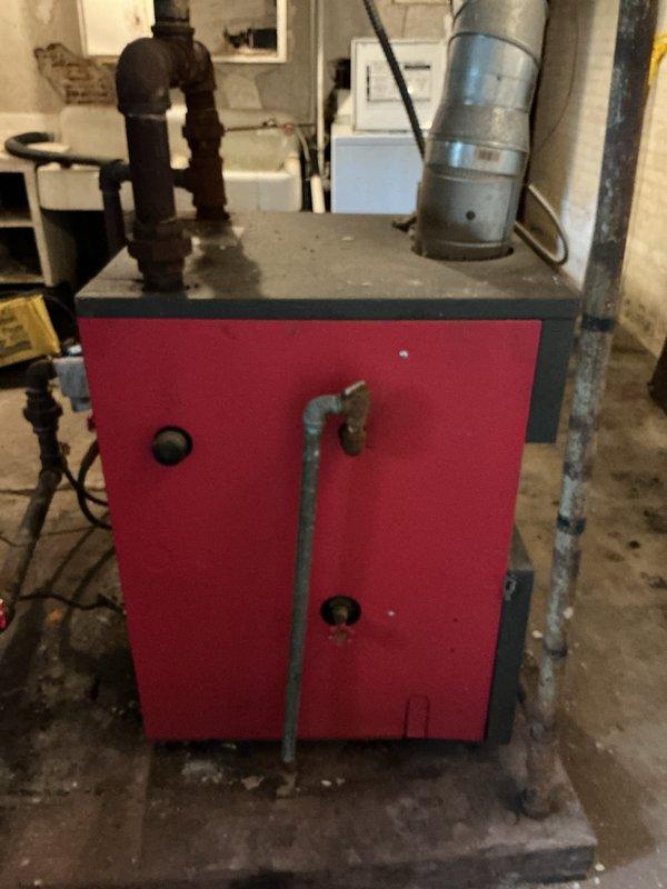 Conducted estimate for replacement of 12-year-old natural gas hot water boiler system currently in operational condition. Assessed existing red and gray panel boiler unit located in basement utility area with associated piping infrastructure and ductwork connections. Replacement recommended due to equipment age and proactive system upgrade considerations. Documented current installation configuration including gas supply lines, hot water distribution piping, and mechanical room layout to facilitate accurate replacement specifications and equipment sizing requirements.