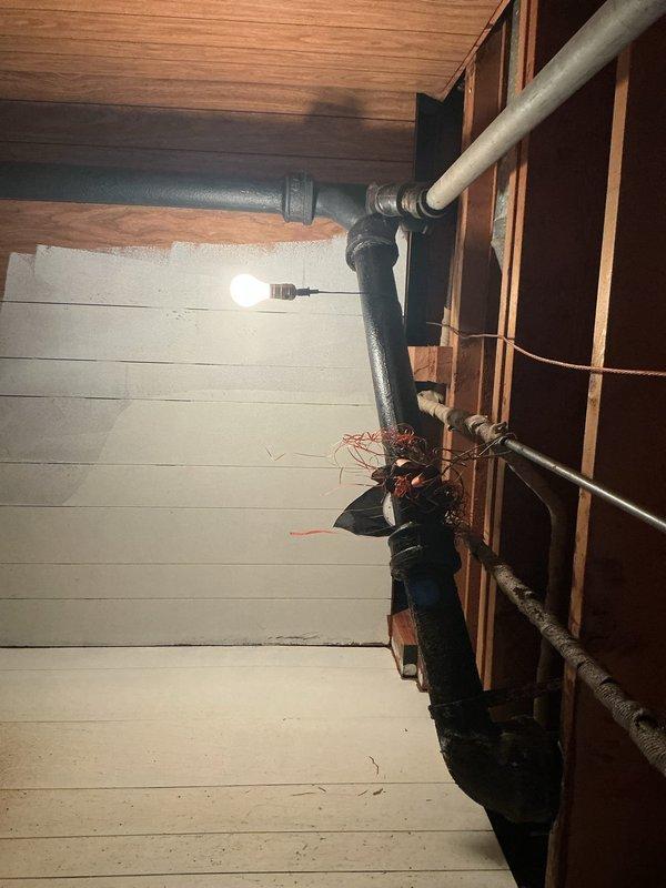 Responded to water leak complaint originating from first-floor bathroom and penetrating through flooring into basement area below. Upon inspection, identified active leak from toilet drain assembly. Accessed basement to examine plumbing system beneath affected bathroom, locating compromised drain pipe connection at vertical stack. Found deteriorated seal at pipe joint allowing water to escape during fixture usage. Repaired faulty connection, replaced worn gasket, and secured all fittings to prevent further water intrusion. Verified repair integrity through water flow testing and confirmed no additional leakage present.
