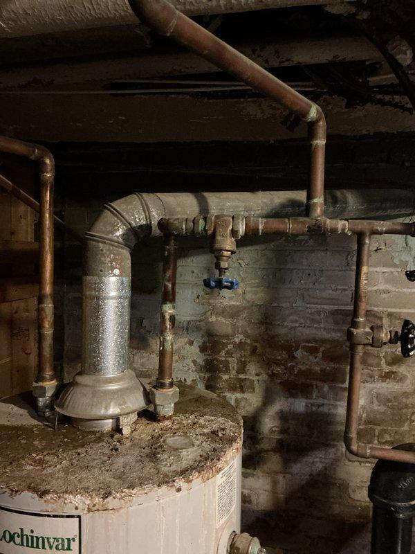 Conducted comprehensive assessment of non-operational 10+ year old natural gas steam boiler system serving radiator-based heating. Evaluated existing Bryant boiler installation, associated piping infrastructure, and distribution system components. Documentation revealed significant equipment age, deteriorated basement conditions with moisture-damaged masonry walls, aged copper piping with oxidation, and compromised venting systems. Confirmed all radiators operational without leaks, but primary unit failure necessitated replacement recommendation due to equipment age and reliability concerns. Provided detailed photographic documentation of existing steam boiler configuration, gas piping, condensate returns, and overall system layout for replacement planning purposes.