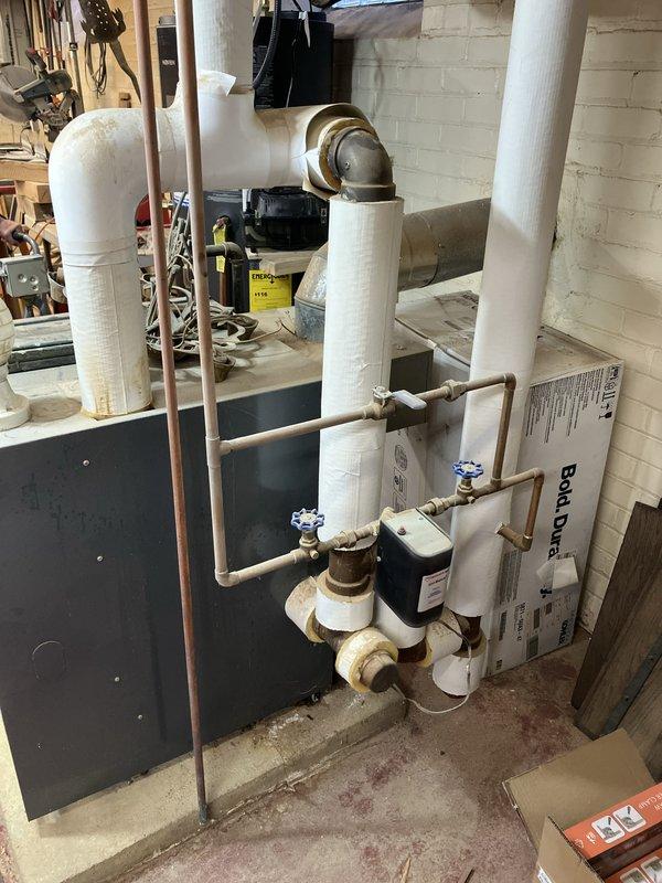 Conducted on-site assessment of 40-year-old Weil-McLain steam boiler system in basement. Identified cracked heat exchanger with active leak requiring immediate attention. Documented existing installation including associated piping, connections, and mechanical components. Photographed current boiler configuration, PVC venting system, copper supply lines, and shut-off valves for replacement planning purposes. Provided comprehensive estimate for complete boiler replacement due to failed heat exchanger beyond economical repair.