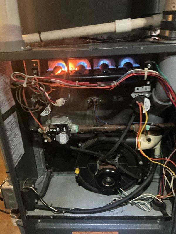 Completed comprehensive Gold Boiler Inspection on 18-year-old hot water boiler and furnace system located in basement of multi-unit property. Verified both units are operational with furnace burners displaying proper blue flame combustion pattern, indicating correct air-fuel mixture and efficient gas burning. Inspected internal components including blower motor assembly, heat exchanger, burner assembly, electrical connections, and control systems. Examined PVC venting and condensate drainage system for proper configuration and clearances. Assessed boiler cabinet interior components including dual burner assemblies, control panel functionality, and insulation integrity. All safety controls, wiring harnesses, and mechanical assemblies found to be in functional condition with no immediate safety concerns identified during inspection.