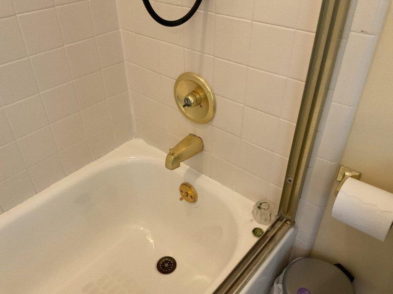 Responded to bathroom faucet leak complaint in bathroom adjacent to kitchen. Upon arrival, inspected all bathroom fixtures including shower valve control, tub spout, and associated plumbing connections. Identified source of leak and performed necessary repairs to eliminate water seepage. Tested all fixtures for proper operation and confirmed no additional leaks present. Work completed successfully with all fixtures functioning properly.