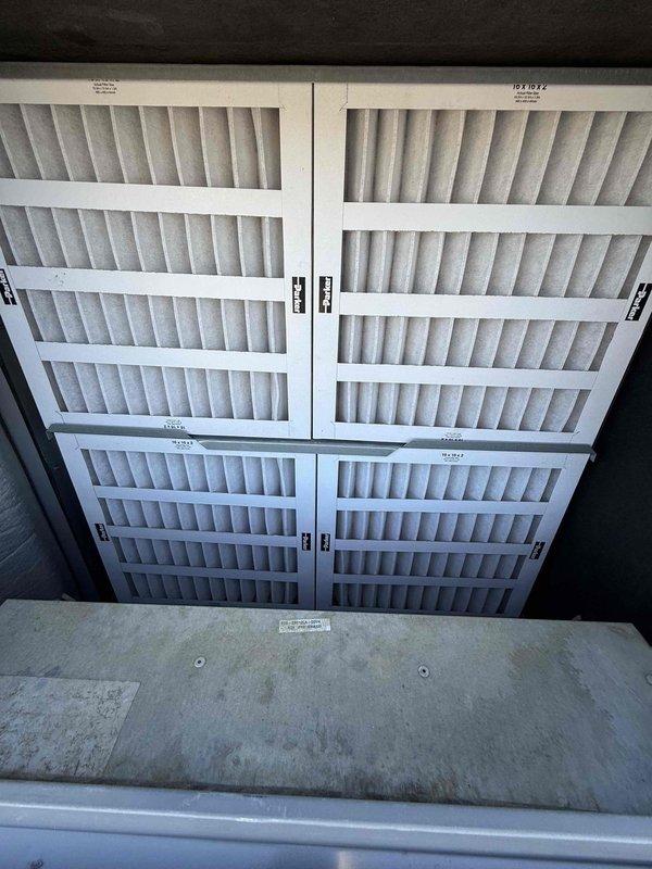 Completed scheduled filter change on commercial rooftop unit requiring lift access. Removed and replaced multiple pleated air filters in the RTU's filter rack system, installing three new filters on the unit exterior and four filters within the 2x2 configuration filter housing. All filters were properly secured with mounting clips and verified for correct fitment to ensure optimal airflow and system efficiency.