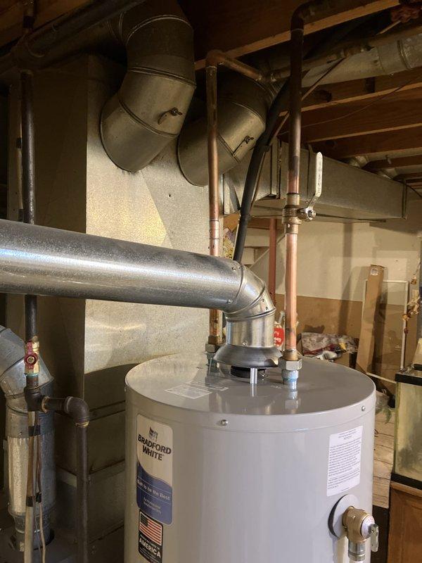 Installed 40-gallon Bradford White standard gas water heater in basement utility room. Connected copper supply and discharge piping, installed pressure relief valve with proper discharge piping, and reconnected gas line with shutoff valve. Vented unit using metallic ductwork to existing chimney system, ensuring proper draft and code compliance. Tested all connections for leaks, verified gas pressure, confirmed proper ignition and burner operation, and ensured temperature and pressure relief valve functionality before placing unit in service.