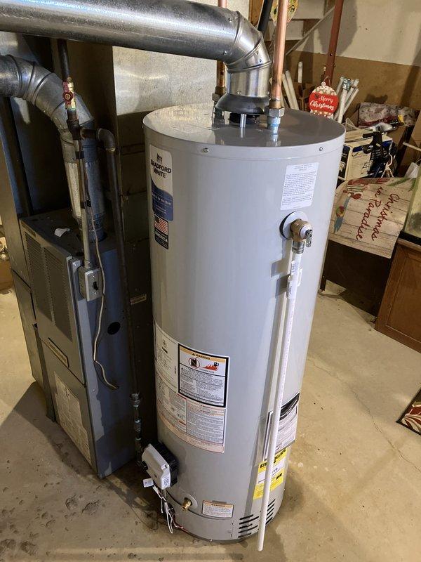 Installed 40-gallon Bradford White standard gas water heater in basement utility room. Connected copper supply and discharge piping, installed pressure relief valve with proper discharge piping, and reconnected gas line with shutoff valve. Vented unit using metallic ductwork to existing chimney system, ensuring proper draft and code compliance. Tested all connections for leaks, verified gas pressure, confirmed proper ignition and burner operation, and ensured temperature and pressure relief valve functionality before placing unit in service.