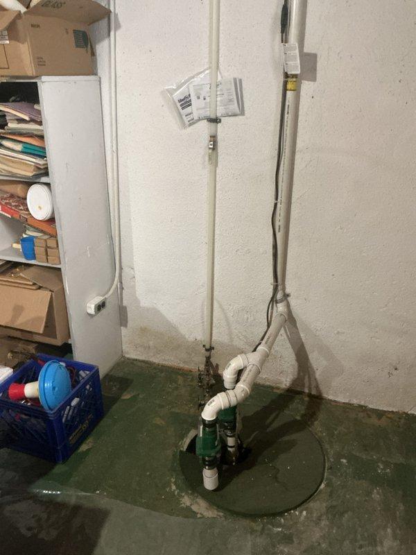 Responded to report of continuously wet area on lawn with suspected underground pipe leak. Upon investigation, inspected exterior drainage system and located storm drain grate showing normal operation with no evidence of subsurface water line failure in that area. Conducted interior inspection of basement plumbing infrastructure, examining sump pump system, discharge piping, and associated connections for potential leak sources. All visible plumbing components, PVC connections, and pump assembly showed proper installation and no active leaks. Documented conditions with photographs for record. Based on investigation findings, wet lawn area may be attributed to drainage patterns or other non-plumbing factors rather than underground pipe leak.
