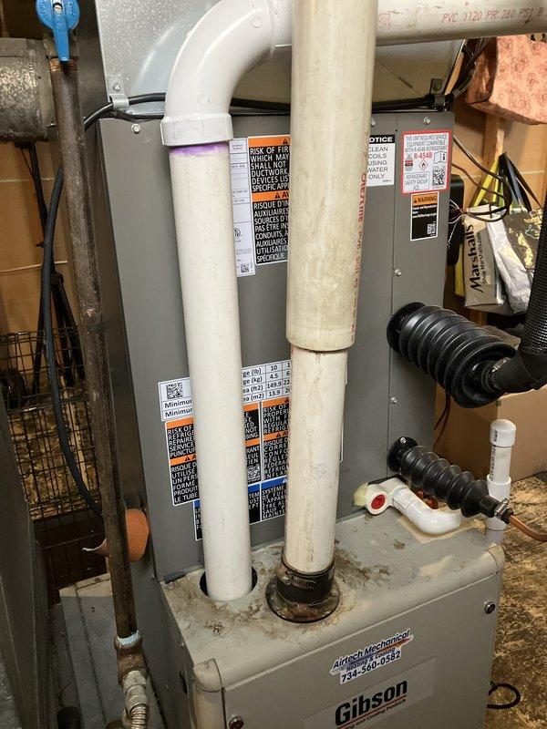 Conducted comprehensive full system estimate for complete HVAC replacement in residential basement installation. Evaluated existing Gibson furnace unit with associated electrical disconnect panels, gas line connections with shutoff valve, PVC condensate drainage system, and flexible return air ducting. Assessed current mechanical room configuration including electrical service panels, ventilation piping routing through floor joists, and utility connections. Documented equipment specifications, clearance requirements, and existing infrastructure conditions. Photographed installation area showing gas piping with blue-handled valve, white PVC drain lines with multiple elbows and fittings, corrugated flexible hoses, electrical wiring bundles, and concrete floor space. Reviewed ceiling joist layout and available routing options for new ductwork and venting systems. Measured clearances around existing equipment platform and evaluated structural framing for new system installation requirement
