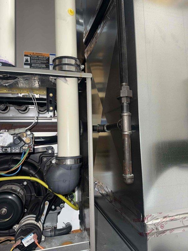 Responded to service call for 11-year-old forced air furnace in basement not producing warm air with thermostat temperature dropping below setpoint. Arrived on-site before 9 AM as requested and contacted customer prior to arrival. Performed diagnostic inspection of furnace system, removing access panel to examine internal components including blower motor assembly, control board, heat exchanger, and electrical connections. Verified all wiring connections at blower motor (yellow, green, red, and white leads) were secure and properly terminated. Inspected control board operation and associated wiring harness for any signs of failure or loose connections. Examined heat exchanger assembly for proper operation and checked condensate drain lines (white PVC piping) for blockages or restrictions. Assessed blower motor functionality and verified proper electrical supply to all system components. Documented equipment condition through photographs showing internal mechanical and electrical compon