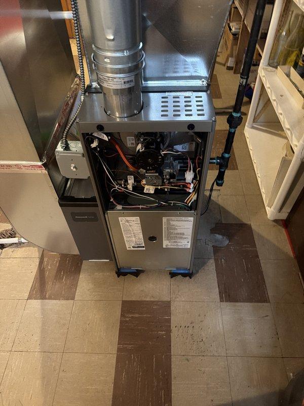 Completed installation of 70,000 BTU gas furnace with new thermostat and humidifier replacement in basement utility area. Obtained mechanical and electrical permits prior to installation, connected all ductwork including flexible and rigid metal piping, and verified proper wiring and electrical connections. Unit installed on protective equipment pads with all components functioning per manufacturer specifications.
